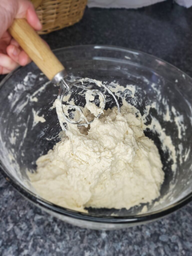 mixing the bread dough until the flour is incorporated